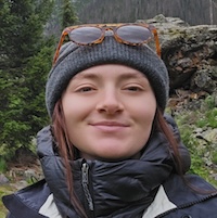 Headshot of a woman smiling in a gray beanie