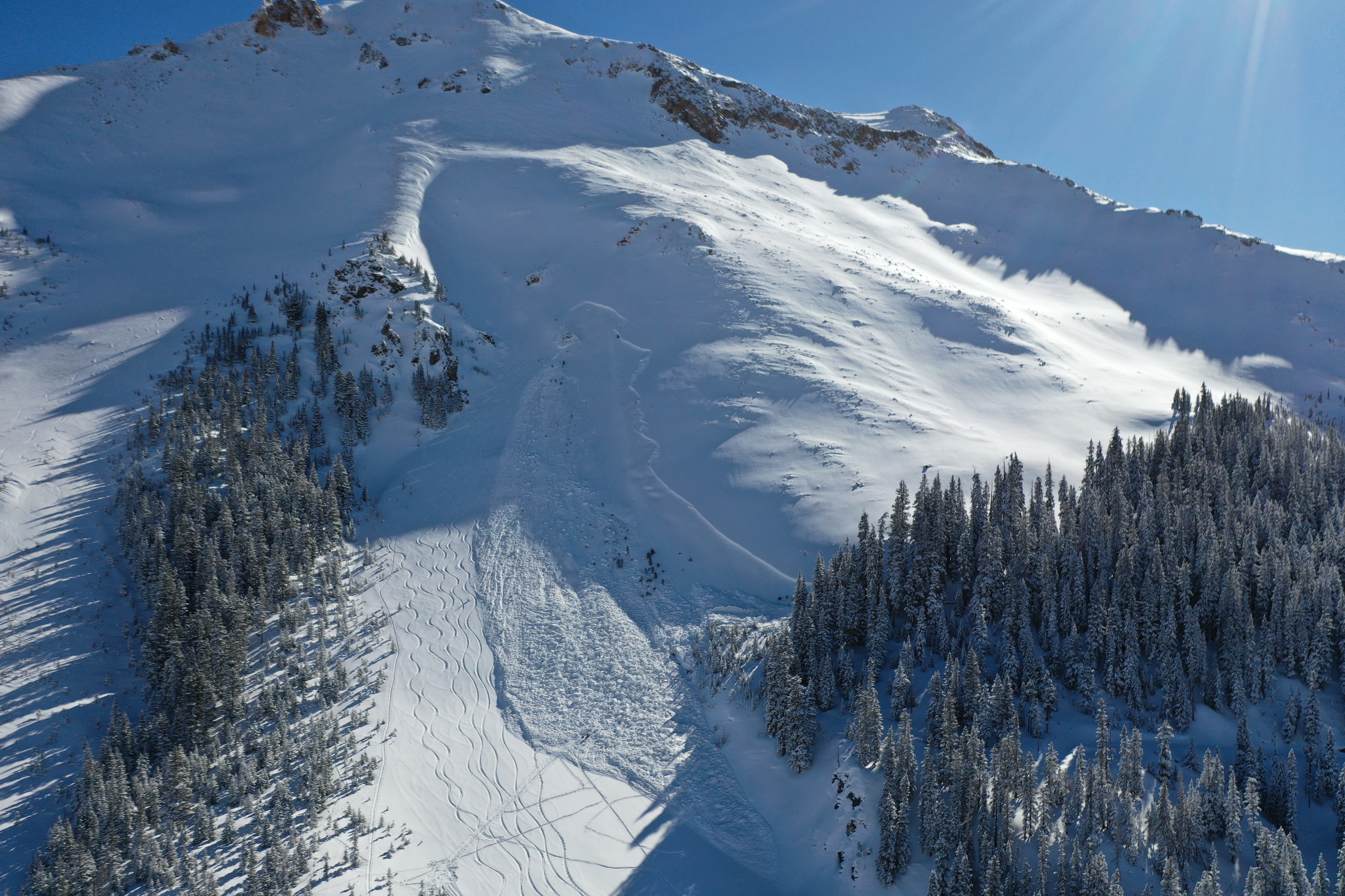 Large avalanche with many ski tracks to the lookers left of it. 