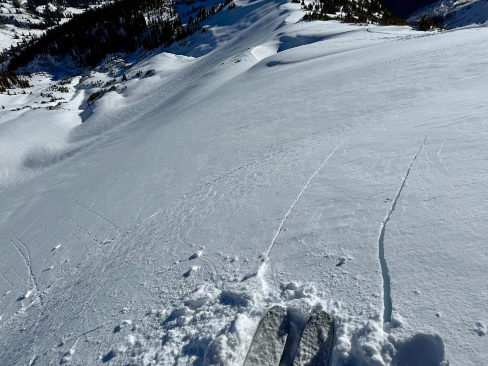 Looking down a wind-loaded rollover, showing cracks in the snow triggered by a skier