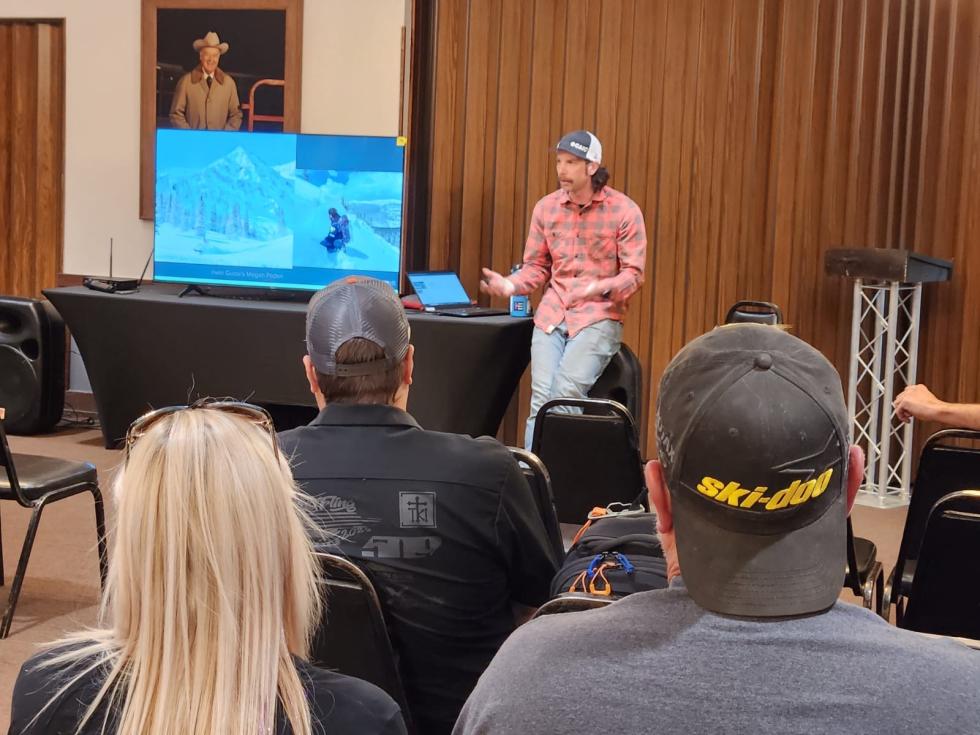 Looking across a group listening to a CAIC staff member present