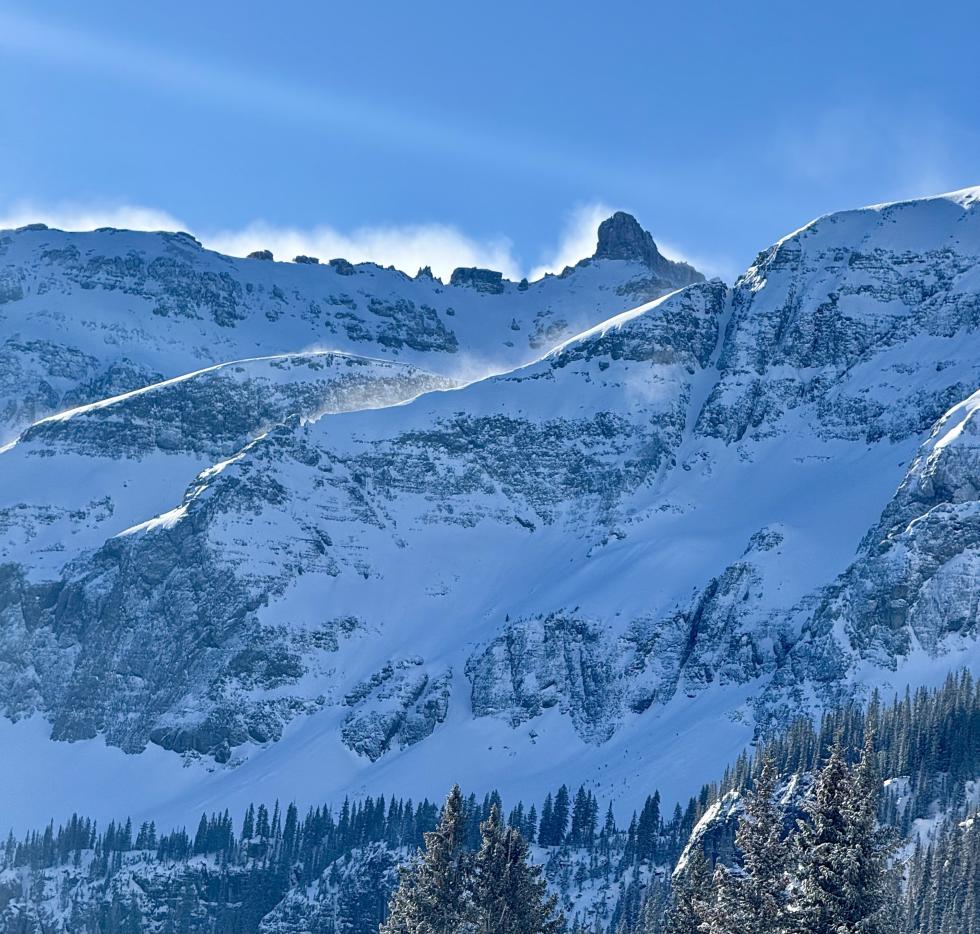Wind blowing snow at the top of a mountain ridgeline