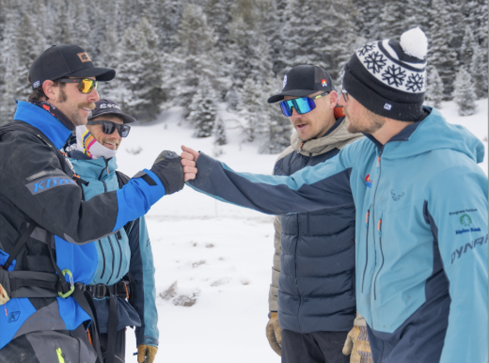 Friends and Friends of CAIC staff touching fists on the snow